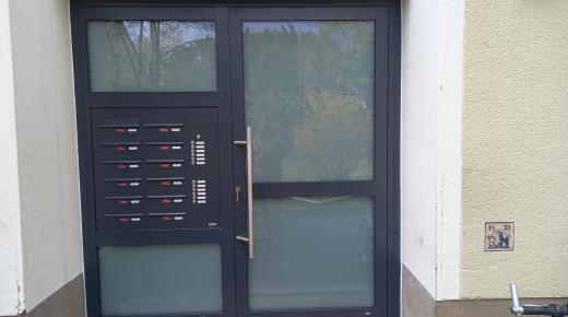 Moderne Haustüranlage für Mehrfamilienhaus mit Briefkästen und Klingelanlagen in Frankfurt