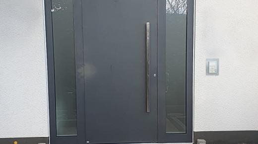 Aluminium-Haustür in dunkelgrau mit Seitenteilen und Stangengriff