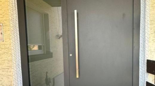 Graue Haustür mit Stangengriff und Seitenteil in Frankfurt